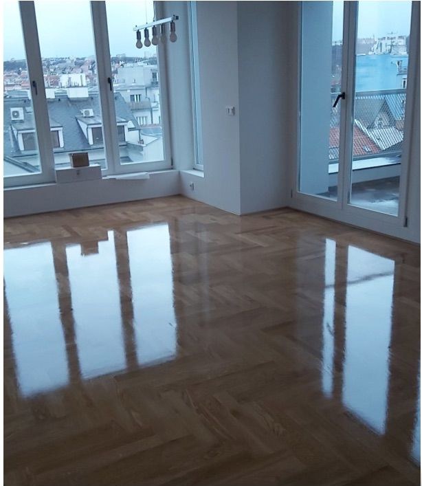 Lesklá rybinová podlaha v bytě s panoramatickými okny